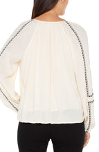 Embroidered Woven Long Raglan Slv Blouse w Tassel Tie Neck Detail
